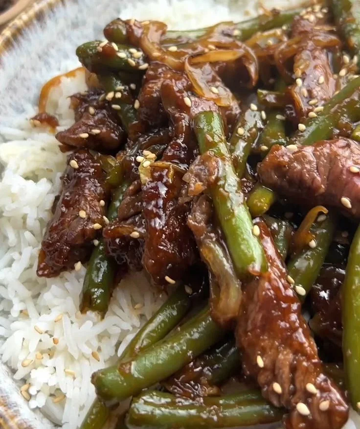 Asiatische Rindfleischstreifen mit grünen Bohnen und Zwiebeln auf einem Teller