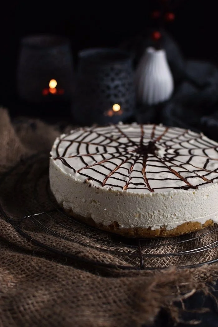 Halloween Cheesecake mit Zimt und Spinnennetz dekoriert