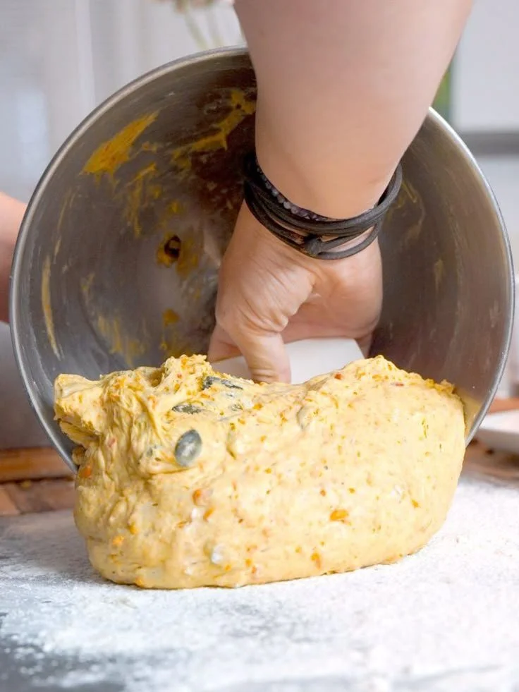 Scheiben von selbstgebackenem Kürbis-Kartoffelbrot auf einem Holzbrett