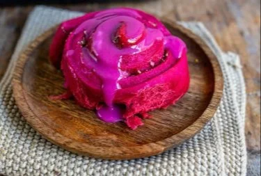 Pinke Zimtschnecken auf einem Teller, frisch gebacken und lecker.