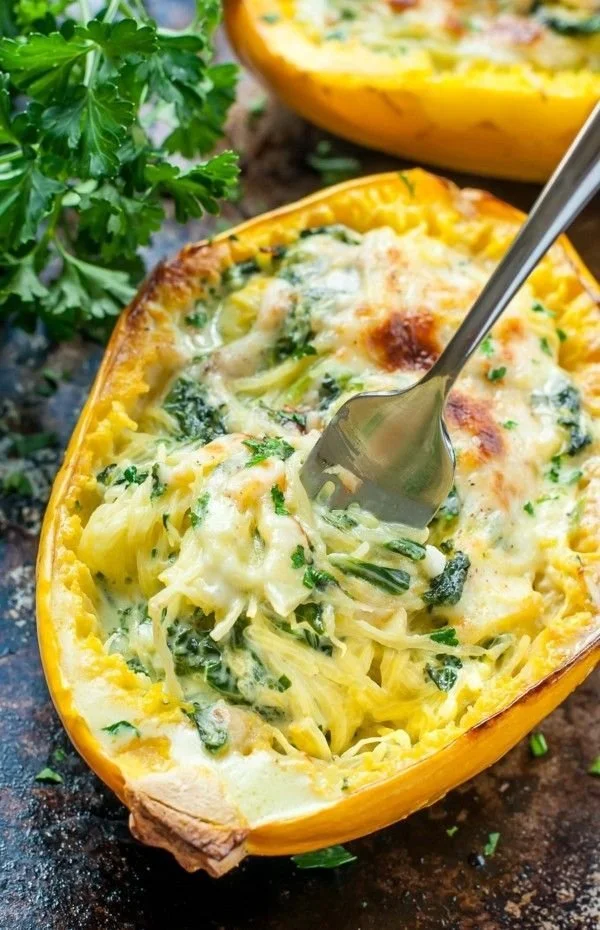 Gekochter Spaghettikürbis auf einem Teller, serviert mit frischen Kräutern.