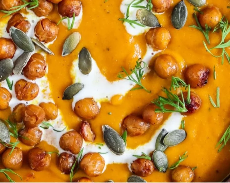 Vegane Kürbissuppe mit knusprigen Kichererbsen, serviert in Schale