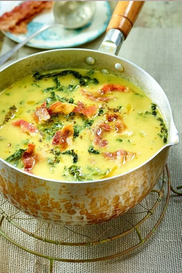 Wirsingsuppe mit Kartoffeln und Speck in einer Schüssel serviert.