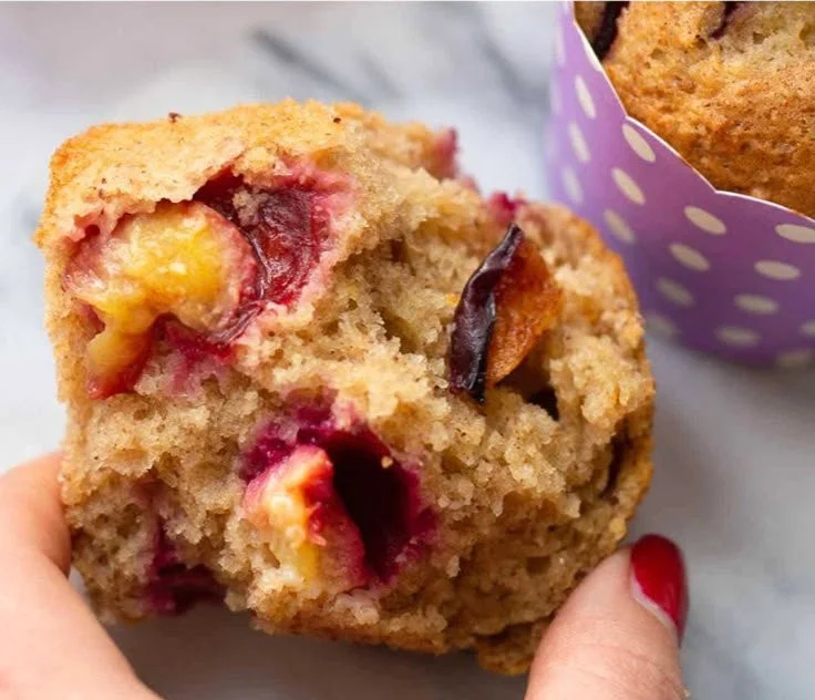 Frisch gebackene Zwetschgen Muffins auf einem Teller.