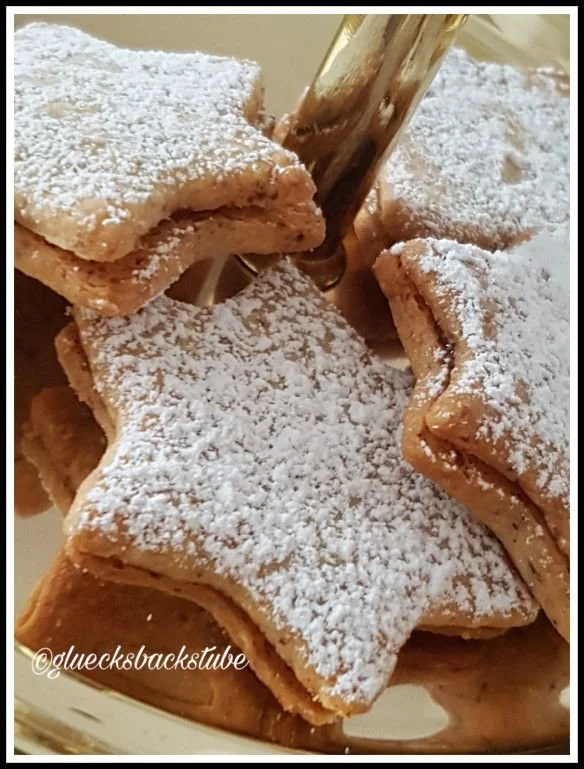 Mürbe Orangensterne-Plätzchen auf einem festlichen Teller